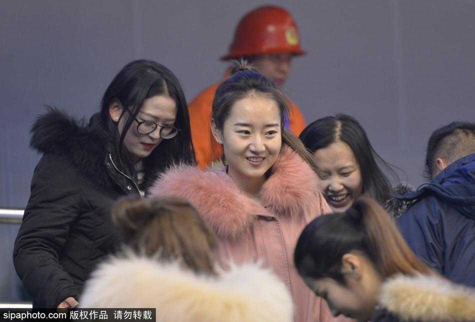 镜头拉近，这位美女球迷身穿简约的深色外套，领口微露，更衬得肌肤胜雪。她手托香腮，若有所思，长长的睫毛在眼睑上投下一片淡淡的阴影，那份安静的美，与周围喧闹的赛场环境形成了奇妙的对比。