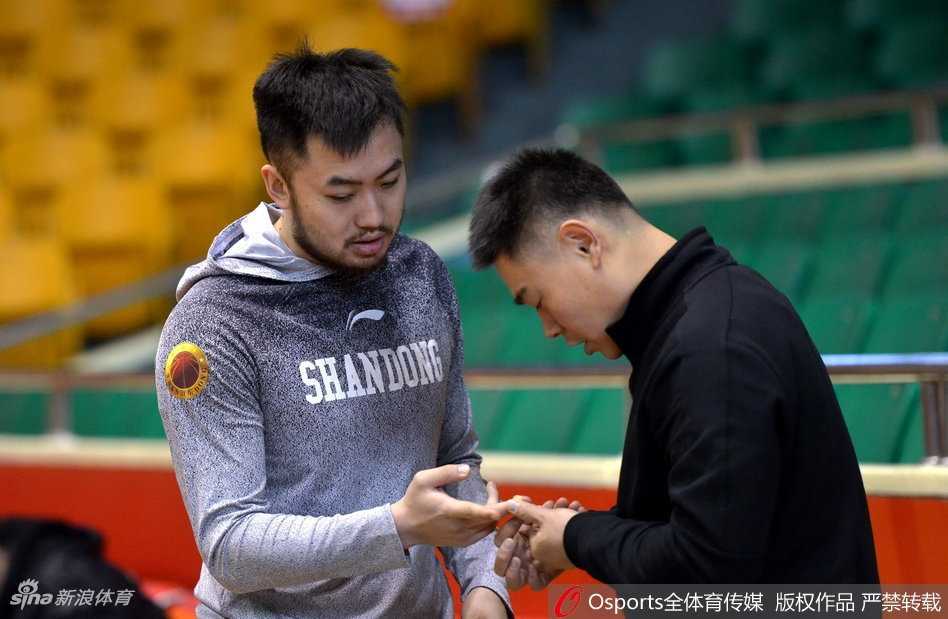 热身活动中，小丁双手抱头做拉伸，却歪着脑袋露出一脸无辜的表情，仿佛在问‘教练，这个动作能不能不做呀？’眼神中透着一丝孩子气的顽皮。