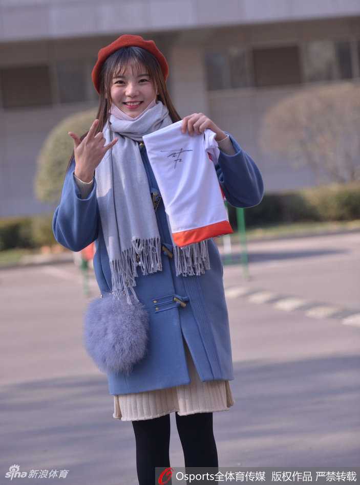 面带甜美微笑的女球迷，仿佛能融化赛场上的所有紧张，她身上洋溢的青春气息与火热的比赛相得益彰。